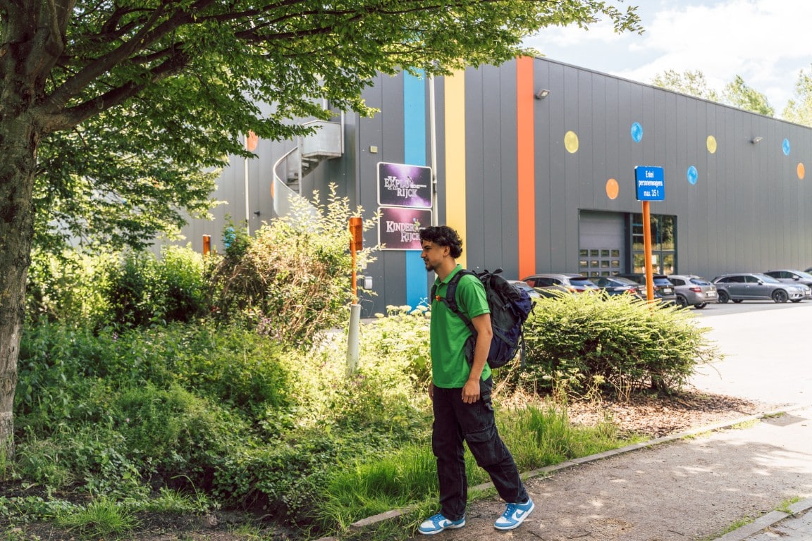Een wandelaar met een rugzak vertrekt aan ExploRijck