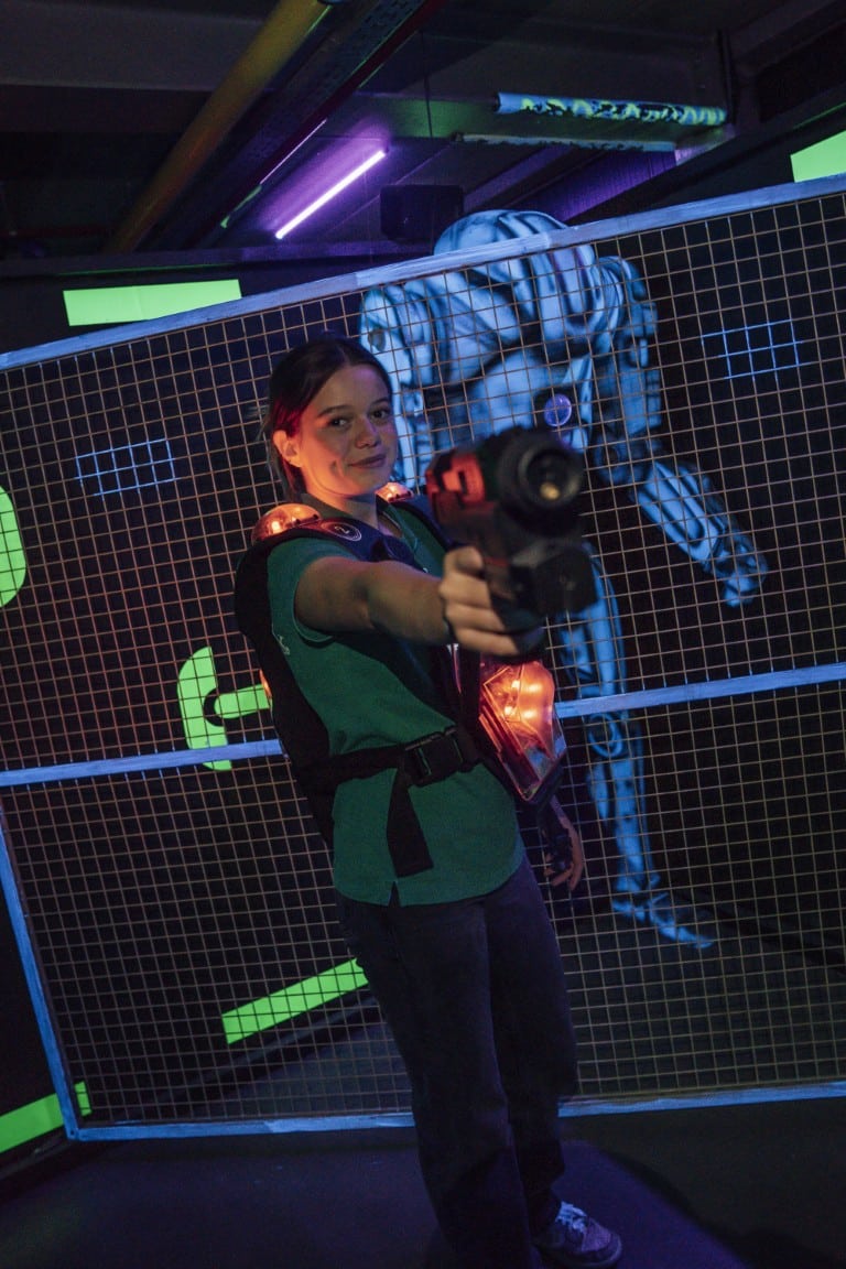 Een speelster met een laserpistool in de arena