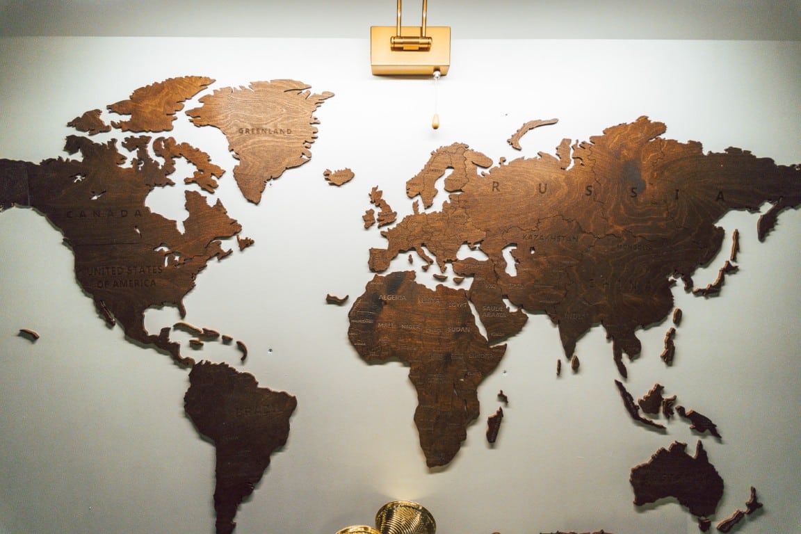 Een houten wereldkaart aan de muur van Het Geheim Archief