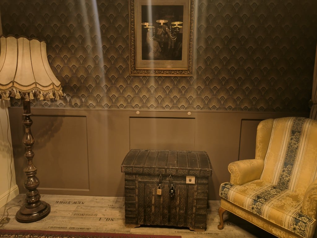 Een staande lamp, een kist en een fauteuil in ’t HiemelRijck