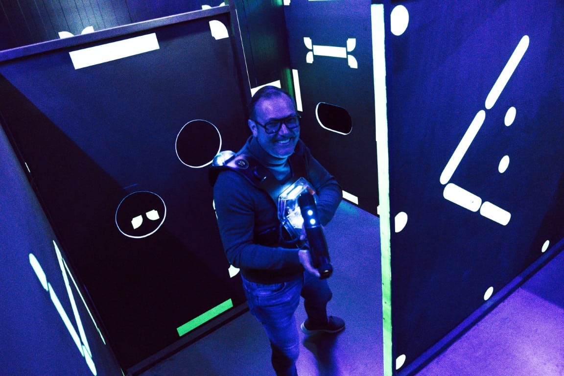 Een speler met een laserpistool tussen de lichtgevende wanden