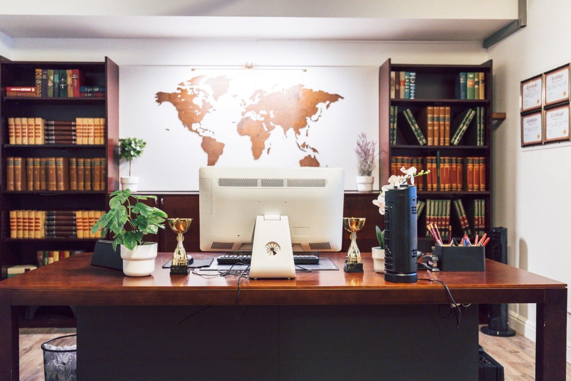Een bureau met boekenkasten en een wereldkaart in Het Geheim Archief