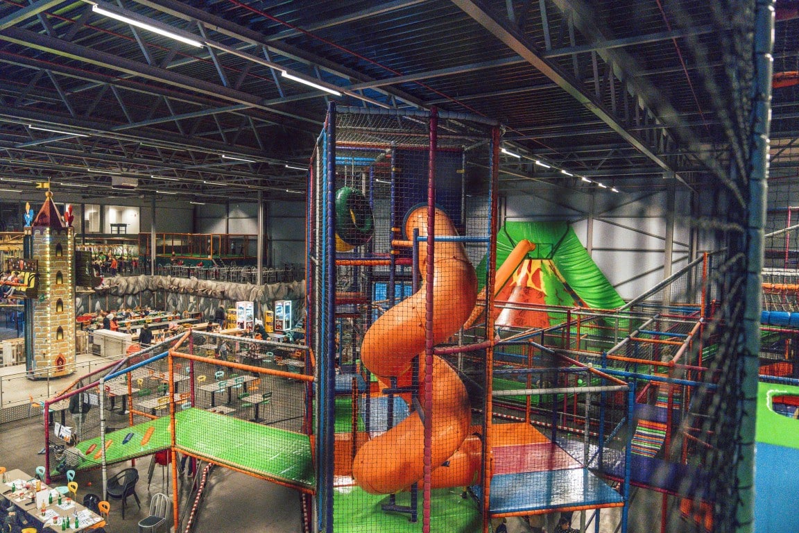 De indoor speeltuin met klimtoren en glijbanen