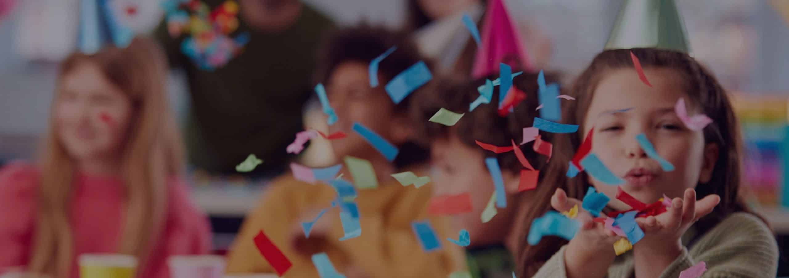 Kinderen blazen confetti op een verjaardagsfeestje