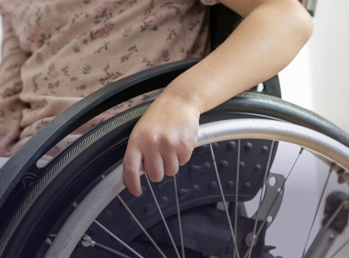 Hand op het wiel van een rolstoel