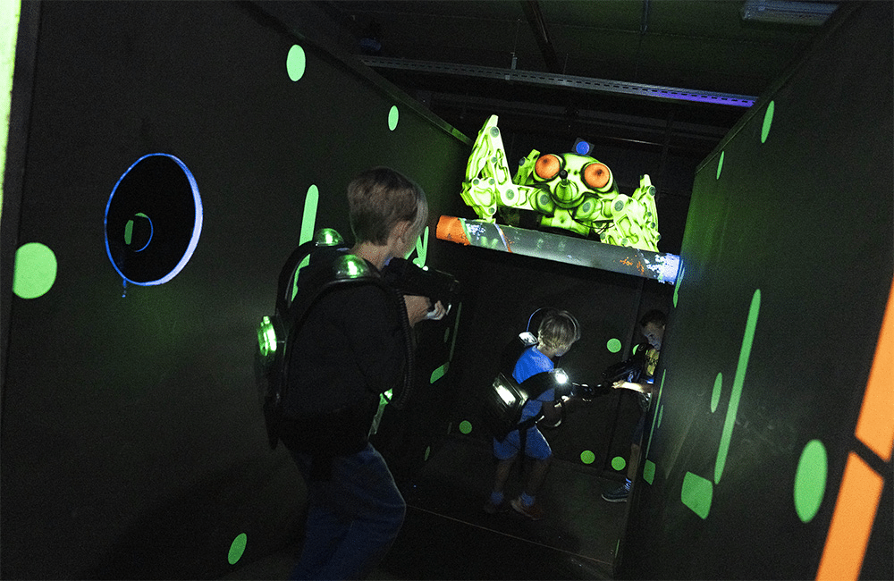 Kinderen spelen lasershoot in de donkere arena