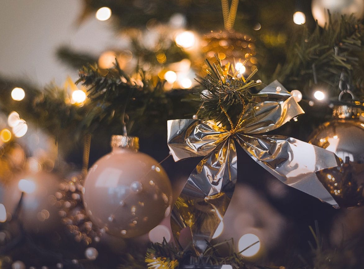 Kerstbal en strik in een verlichte kerstboom