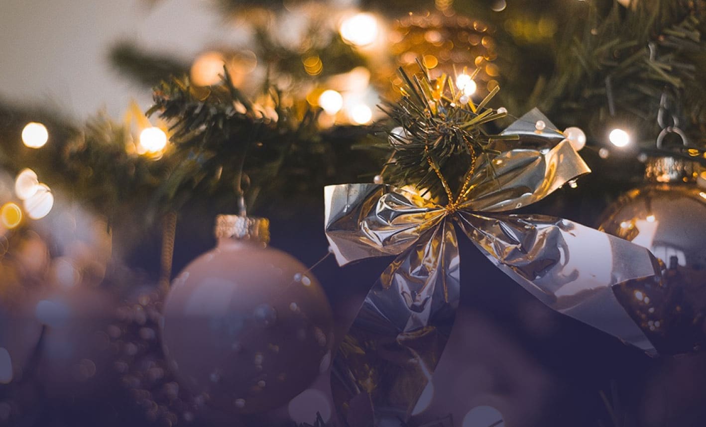 Kerstbal en strik in een verlichte kerstboom