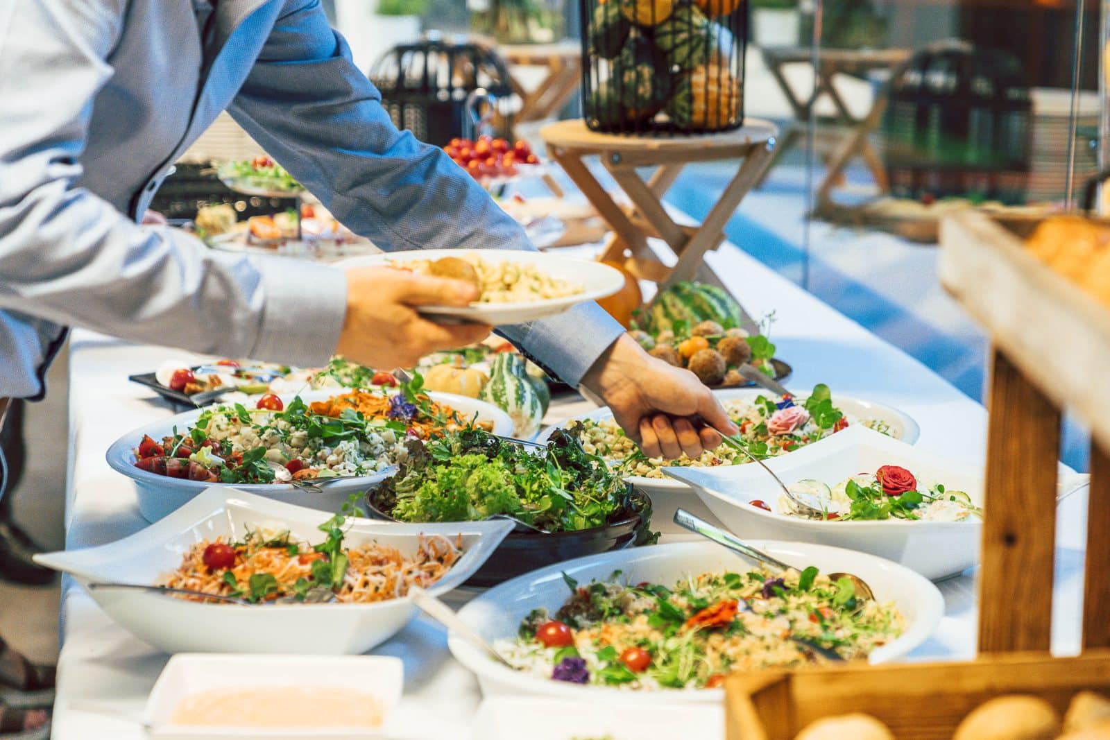 Gast schept salade op aan het brunchbuffet